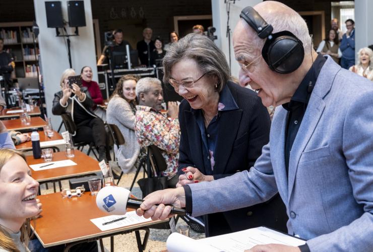 een man interviewt winnaar van een dictee