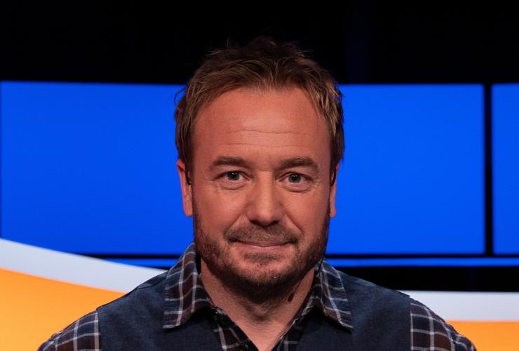 Man met geruite blouse en blauw gilet 