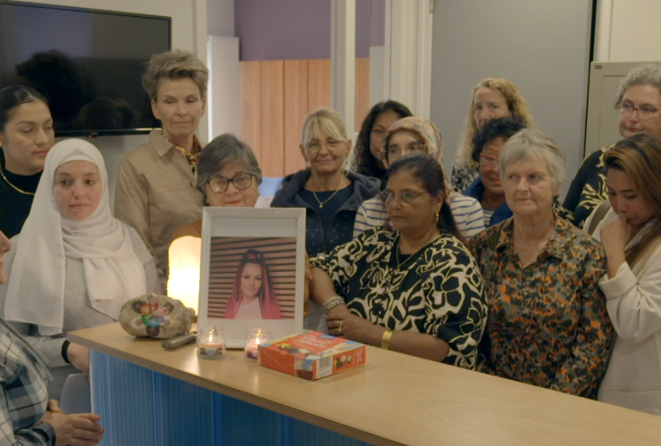 Groep vrouwen brandt een kaarsje bij een foto