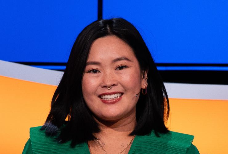 Lachende mevrouw met zwart haar en groene blouse