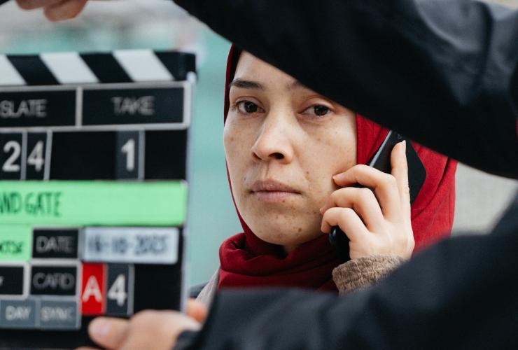 een achter de schermen foto van een vrouw die belt in docuserie Holland Gate