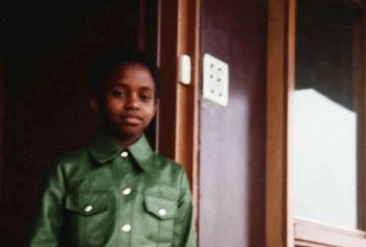 Meisje met groene jas in deuropening