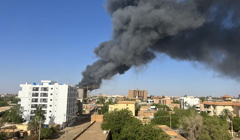 A column of smoke rises behind buildings near the airport area in Khartoum on April 19, 2023, amid fighting between the army and paramilitaries following the collapse of a 24-hour truce. AFP