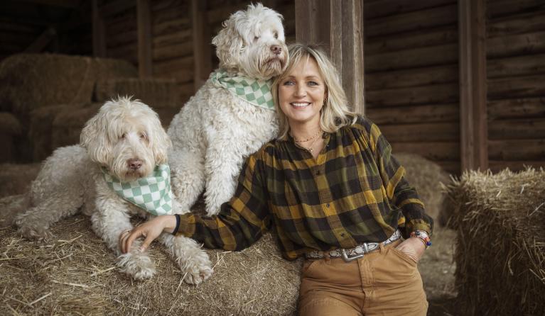 een vrouw poseert met twee honden