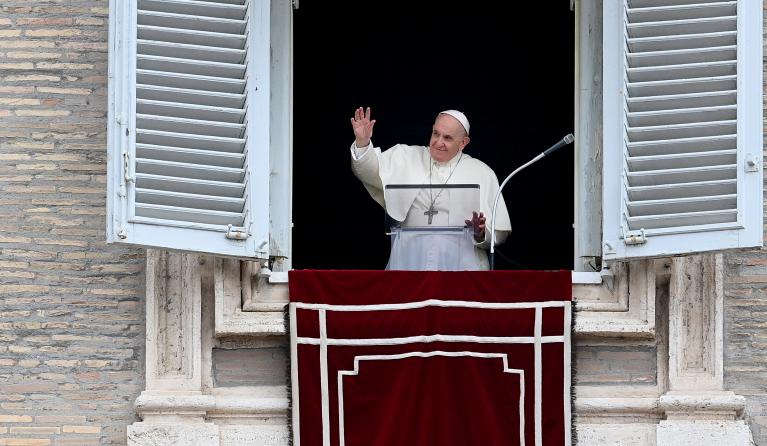 Pope Francis waves to attendees from the window of the apostolic palace overlooking St. Peter's Square during the weekly Angelus prayer on September 26, 2021 in The Vatican.  Vincenzo PINTO / AFP