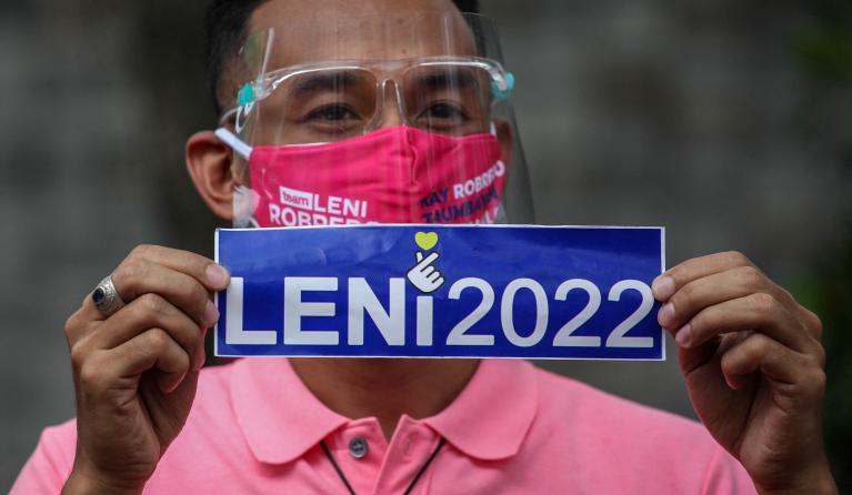A man holds signage supporting Philippine Vice President Leni Robredo on her candidacy to join the 2022 presidential race outside the Cultural Center of the Philippines in Pasay, Metro Manila on October 7, 2021.
