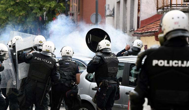 Police forces stand amidst tear gas smoke during clashes following a protest against the inauguration of the new head of the Serbian Orthodox Church on September 5, 2021 in the historic city of Cetinje in Montenegro. The new head of the Serbian Orthodox Church in Montenegro was inaugurated, arriving by helicopter under the protection of police who dispersed protesters with tear gas. The decision to anoint Bishop Joanikije as the new Metropolitan of Montenegro at the historic monastery of Cetinje has aggrava