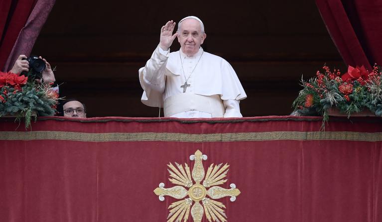 Pope Francis waves from the balcony prior to giving his Christmas Urbi et Orbi blessing to the gathered faithful in St. Peter's Square at The Vatican on December 25, 2021