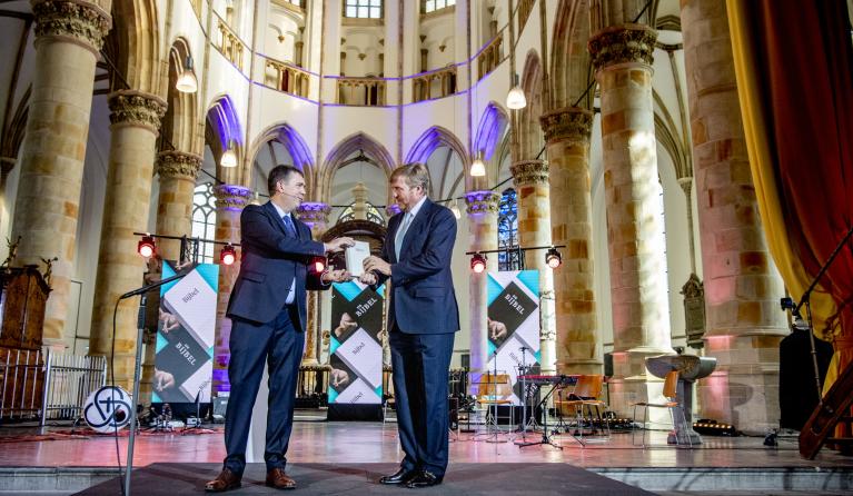 Koning Willem Alexander neemt in de Grote Kerk het eerste exemplaar van de NBV21, de vernieuwde Nieuwe Bijbelvertaling, in ontvangst. Koning Willem Alexander is beschermheer van het Nederlands-Vlaams Bijbelgenootschap. 