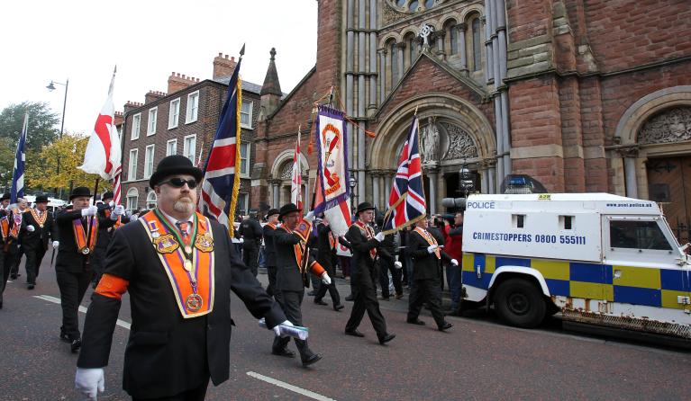Orangemen march past St.Patrick Catholic Church in north Belfast, Northern Ireland on September 29, 2012. Northern Ireland braced for one of its biggest Protestant parades in years, with police on high alert as pro-British marchers took to the streets of Belfast. Some 30,000 people were expected to join the march marking the 100th anniversary of the Ulster Covenant, a landmark declaration signed by nearly half a million Protestants who vowed to defend themselves against rule from Dublin. AFP PHOTO/ Peter Mu