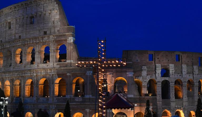 A general view shows a cross lit with candles by the Colosseum (Coliseum, Colosseo) monument for the Via Crucis (Way of the Cross) torchlight procession of Good Friday, on April 19, 2019 in Rome.