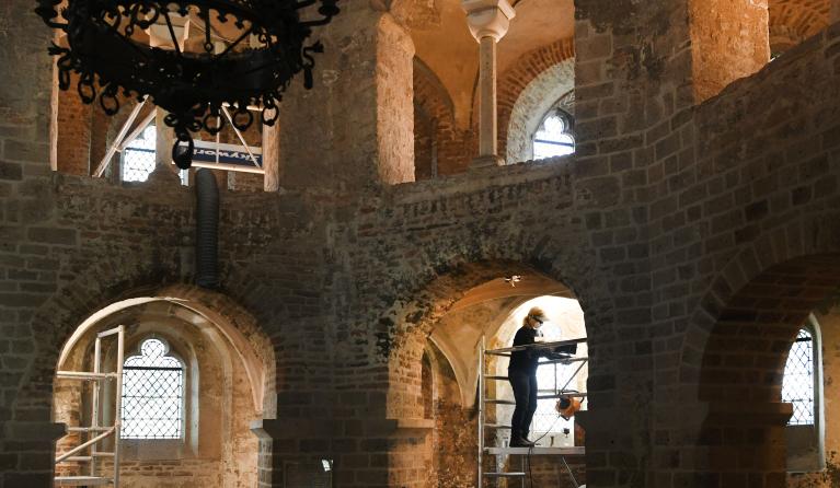 Een restaurateur reinigt een muurschildering in de Sint-Nicolaaskapel. De schilderingen dateren uit 1543 en zijn aangebracht om de komst van Keizer Karel V naar Nijmegen te vieren. 