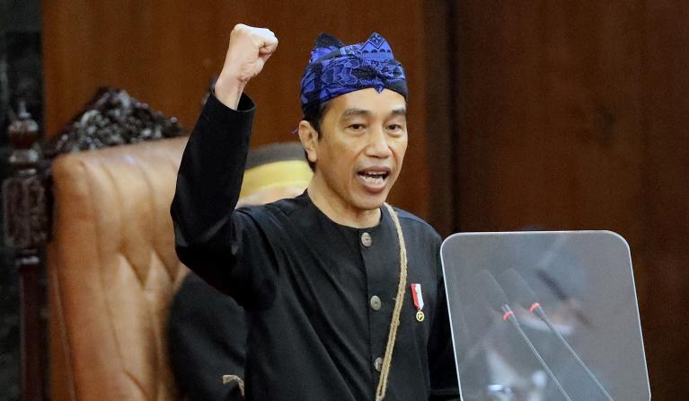 Indonesia's President Joko Widodo, dressed in a traditional costume of the Baduy tribe from Banten province, gestures during his state-of-the-nation address at a general assembly of parliament in Jakarta on August 16, 2021