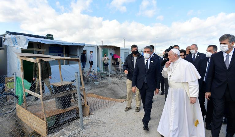 This handout photograph taken on December 5, 2021 and released by Vatican Media shows Pope Francis meeting refugees at the Reception and Identification Centre in Mytilene on the island of Lesbos. 