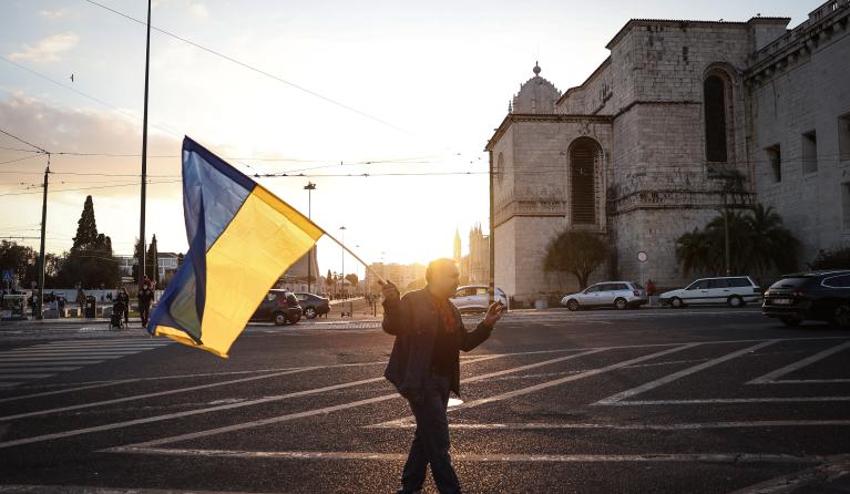 iemand met een wapperende oekraiense vlag met ondergaande zon