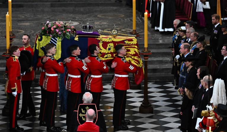 The Bearer Party of The Queen's Company, 1st Battalion Grenadier Guards carries the coffin of Queen Elizabeth II, draped in a Royal Standard and adorned with the Imperial State Crown and the Sovereign's orb and sceptre inside the Abbey at the State Funeral Service for Britain's Queen Elizabeth II, at Westminster Abbey in London on September 19, 2022. Leaders from around the world will attend the state funeral of Queen Elizabeth II. The country's longest-serving monarch, who died aged 96 after 70 years on th
