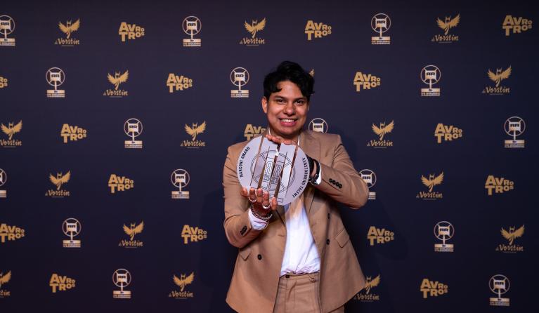 Andres Odijk met de prijs in zijn hand voor een achterwand van de RadioRing