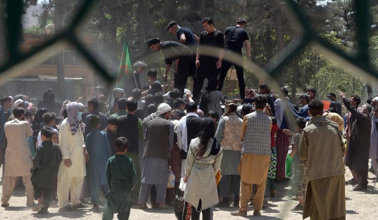 Internally displaced Afghan people, who fled from the northern province due to battle between Taliban and Afghan security forces, gather to receive free food being distributed by Shiite men at Shahr-e-Naw Park in Kabul on August 13, 2021.  WAKIL KOHSAR / AFP