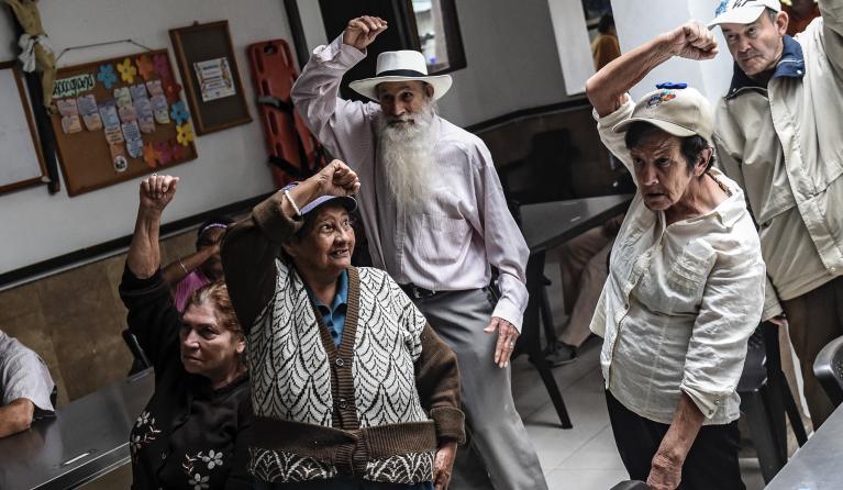 Elderly people work out as they watch an online excercise class at a nursing home during the COVID-19 pandemic in Medellin, Colombia on May 22, 2020. Due the crisis caused by the COVID-19 pandemic, the Colombian government decreed that adults over 70 years old cannot leave their homes. JOAQUIN SARMIENTO / AFP