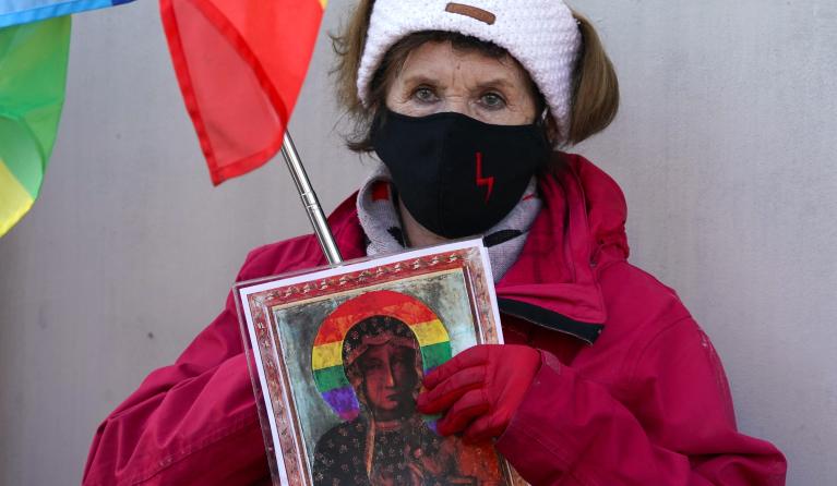 A supporters of the Polish LGBT activists holds a picture of Virgin Mary with a rainbow halo, in front of the court in Plock, Poland, on March 2, 2021. A Polish court on March 2, 2021 acquitted three gay rights activists who were accused of offending religious sentiment after they put up posters of the Virgin Mary with a rainbow halo. 