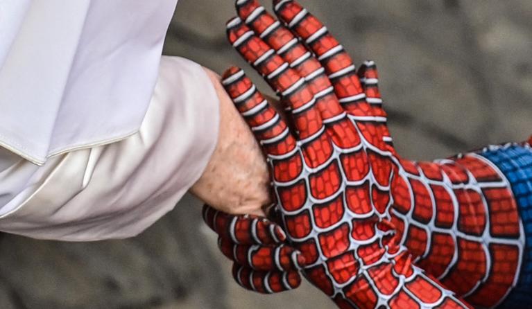 A man wearing a costume of the Spider-Man fantasy character, who performs in hospitals for sick children, shakes hand with Pope Francis at the end of the weekly general audience on June 23, 2021 at San Damaso courtyard in the Vatican. 