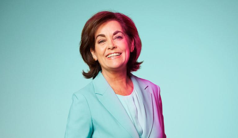 Jacobine Geel poseert voor een lichtblauwe achtergrond