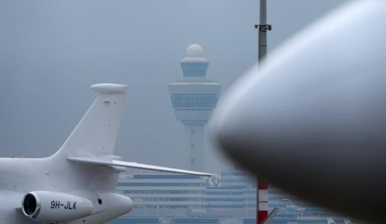 Een vliegtuig bij een verkeerstoren