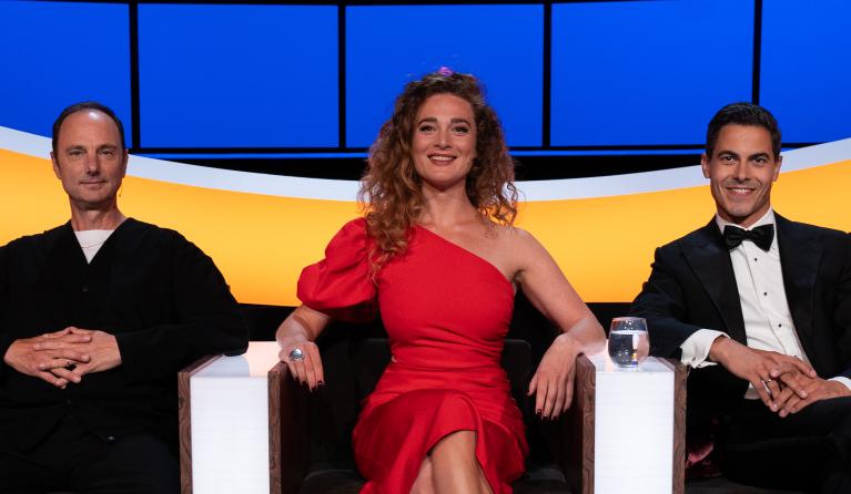 Twee mannen en een vrouw in een studio