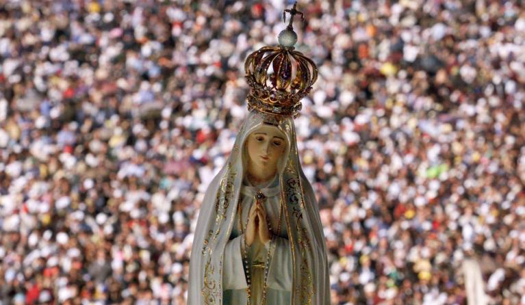 General view of the crowd with a statue of the Virgin of Fatima 13 May 2000, as Pope John Paul II celebrates the mass of beatification of the two dead shepherds children, Jacinta and Francisco Marto in Fatima. The children where witnesses of the Fatima miracle (the Virgin Mary was said to have appeared to the children and gives them three messages) in 1917 along with her cousin Lucia Dos Santos, who is now 93-year-old and lives as a nun under the name of Sister Santa Maria Lucia of the Immaculate Heart. (EL