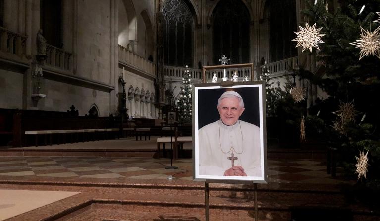 A portrait of Pope Emeritus Benedict XVI is seen near the altar at the Cathedral of Regensburg, southern Germany on December 29, 2022, during a church service. Former pope Benedict XVI remains in a serious but stable condition, Italian media reported on December 29, the day after the Vatican revealed the 95-year-old's health had deteriorated. Florian CAZERES / AFP