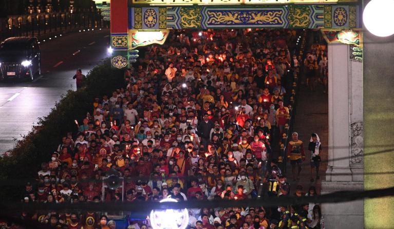 Roman Catholic devotees, some carrying miniature statues of the Black Nazarene and candles, walk along a street dubbed "walk of faith" as they celebrate the annual feast of the Black Nazarene in Manila on January 8, 2023, which devotees believed to have miraculous powers. Ted ALJIBE / AFP