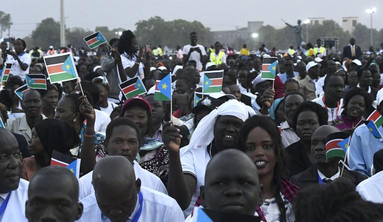 Attendees hold South Sudan flags ahead of the holy mass with Pope Francis at the John Garang Mausoleum in Juba, South Sudan, on February 5, 2023. Pope Francis wraps up his pilgrimage to South Sudan with an open-air mass on February 5, 2023 after urging its leaders to focus on bringing peace to the fragile country torn apart by violence and poverty. The three-day trip is the first papal visit to the largely Christian country since it achieved independence from Sudan in 2011 and plunged into a civil war that 