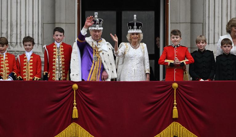 Britain's King Charles III wearing the Imperial state Crown, and Britain's Queen Camilla wearing a modified version of Queen Mary's Crown wave from the Buckingham Palace balcony after viewing the Royal Air Force fly-past in central London on May 6, 2023, after their coronations. The set-piece coronation is the first in Britain in 70 years, and only the second in history to be televised. Charles will be the 40th reigning monarch to be crowned at the central London church since King William I in 1066. Oli SCA