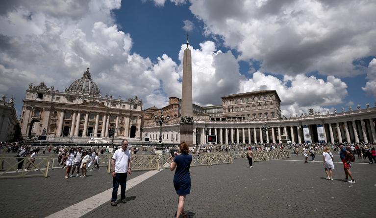 Tourists and locals walk in St. Peter's Square in the Vatican City, on June 11, 2023. Pope Francis, on the advice of doctors, skipped the usual Angelus prayer from the apostolic palace in St. Peter's Square after undergoing an operation for an abdominal hernia on June 7 at a Rome hospital, which was completed 'without complications', the Vatican said. Tiziana FABI / AFP
