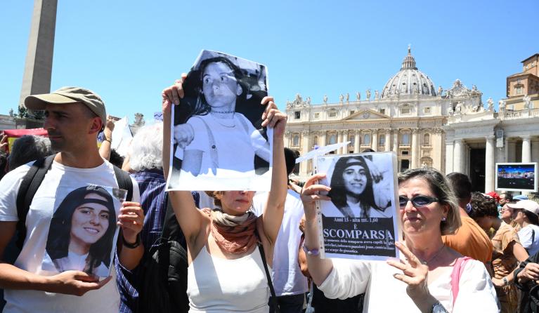People hold placards with Emanuela Orlandi's portrait at the end of Pope's Angelus prayer in St. Peter's Square at the Vatican, on June 25, 2023. Emanuela Orlandi disappeared while returning home in Rome on June 22, 1983. VINCENZO PINTO / AFP