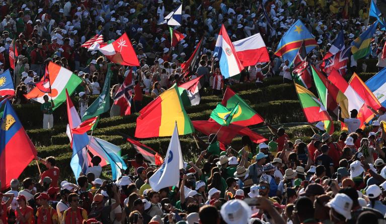 Participants wave flags during the welcoming ceremony of World Youth Day (WYD) gathering of young Catholics, at Eduardo VII Park in Lisbon on August 3, 2023. Pope Francis today urged young people to focus on caring for the planet and fighting climate change, calling for an "integral ecology" that melds environmental protection with the fight against poverty and other social problems. Around one million pilgrims from around the world will attend the World Youth Day, the largest Catholic gathering in the worl
