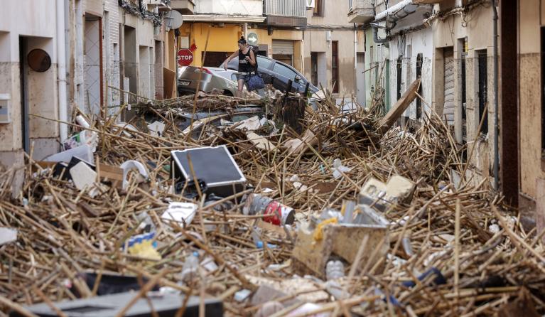 A resident walks over debris in the flood-hit municipality of Paiporta, in the province of Valencia, Spain, 30 October 2024. 