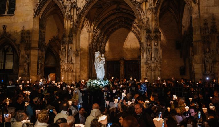Faithfull carry a replica of the "Vierge a l'Enfant" (The Virgin of Paris) a 14th-century statue, in front of the Church of Saint-Germain l'Auxerrois, before heading to Notre-Dame Cathedral for her return, in Paris on November 15, 2024. The Vierge a l'Enfant statue was saved from the fire that ravaged Notre-Dame Cathedral on April 15, 2019, and is being returned during a torchlight procession through the streets of the French capital. Dimitar DILKOFF / AFP