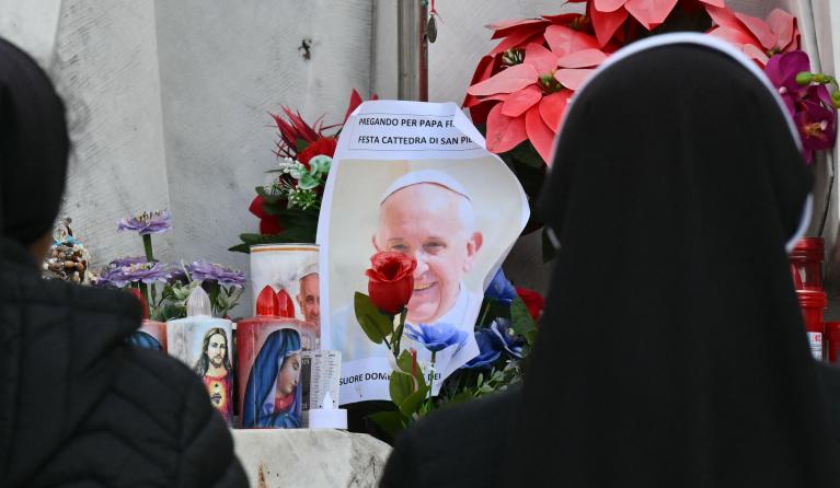 Nuns pray at the statue of John Paul II outside the Gemelli hospital where Pope Francis is hospitalized for pneumonia, in Rome on February 23, 2025. Pope Francis had a quiet night in hospital, the Vatican said on February 23, 2025, the morning after revealing the 88-year-old was in a "critical" condition. "The night passed peacefully, the pope rested," the Holy See said in a short update.