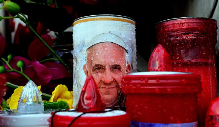 Candles depicting Pope Francis are placed at the statue of John Paul II outside the Gemelli hospital where Pope Francis is hospitalized in Rome on February 24, 2025. Pope Francis, in a critical condition in hospital with pneumonia, had a good night and was resting, the Vatican said on February 24, 2025. "The night passed well, the pope slept and is resting", it said in a brief statement as Francis, 88, entered his 14th day at the Gemelli hospital in Rome, making this the longest hospitalization of his papac
