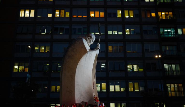 A picture shows the statue of John Paul II at night at the Gemelli University Hospital where Pope Francis is hospitalized with pneumonia, in Rome on March 5, 2025. Dimitar DILKOFF / AFP