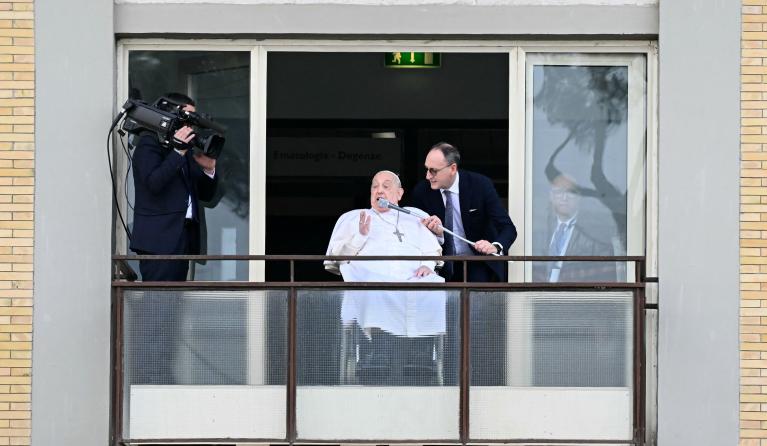 Pope Francis addresses the crowd from a window of the Gemelli hospital before being discharged following a five weeks hospitalization for pneumonia, in Rome on March 23, 2025. Pope Francis is to leave hospital todayand return to his residence in the Vatican, where he is to spend "at least two months" recovering, one of his doctors announced during a press conference on March 22, 2025.