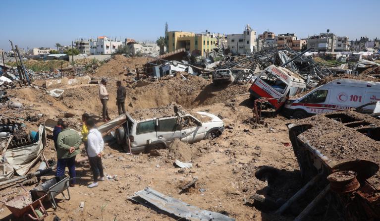 Palestinians inspect the damage at an ambulance repair yard hit in Israeli strikes in the al-Maghazi refugee camp in the central Gaza Strip on March 24, 2025. Israel on March 18 resumed military operations in the Gaza Strip after a period of relative calm since a January 19 ceasefire with Hamas paused more than 15 months of war, citing deadlock in indirect negotiations on next steps in the truce after its first stage expired earlier in March. Eyad BABA / AFP