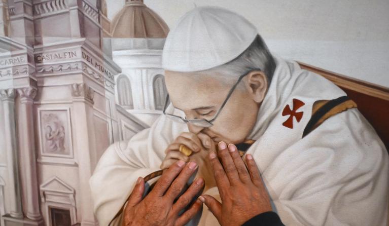 Catholic faitful touch a painting depicting Pope Francis at the Basilica San Jose de Flores in Buenos Aires on April 21, 2025, following the death of Pope Francis in the Vatican. The Basilica de San Jose de Flores was the church where Pope Francis was inspired to consecrate his life to God and the Catholic Church. Pope Francis died on April 21, 2025 aged 88, a day after making a much hoped-for appearance at Saint Peter's Square on Easter Sunday, the Vatican said in a statement. Luis ROBAYO / AFP