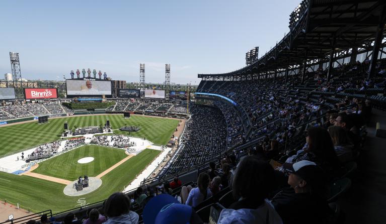 Catholic faithful watch a message from Pope Leo XIV broadcasted on a giant screen during a celebration held in his honor at Rate Field, home of the MLB’s White Sox, in Chicago, Illinois on June 14, 2025. KAMIL KRZACZYNSKI / AFP