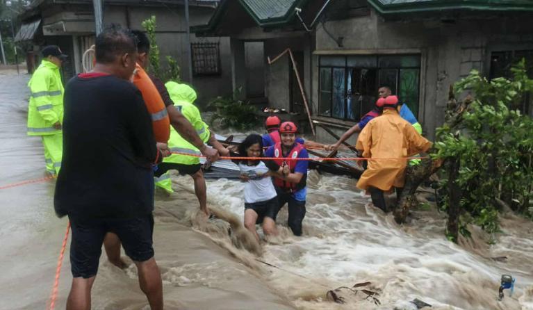 This handout photo taken on September 26, 2025 and received through the Facebook page of Palanas Municipal Disaster Risk and Reduction Management Office (MDRRMO) shows rescuers evacuating residents from their flooded house during Severe Tropical Storm Bualoi in Palanas, Masbate province. The Philippines evacuated hundreds of thousands of people and confirmed at least three deaths on September 26 as it faced yet another tropical storm, days after it was battered by deadly Super Typhoon Ragasa. Handout / PALA