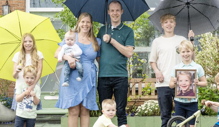 Een groepsfoto van een familie met paraplu's