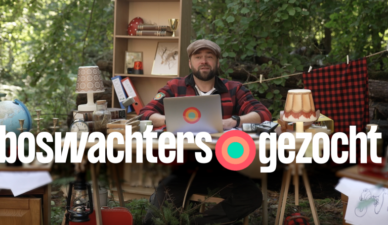 Boswachter Tim achter een bureau in het bos