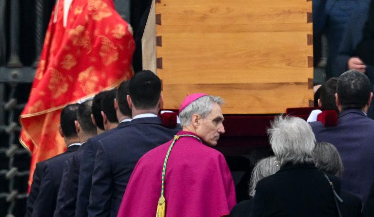 Pallbearers, followed by German Archbishop Georg Gaenswein (C), carry away the coffin of Pope Emeritus Benedict XVI at the end of his funeral mass at St. Peter's square in the Vatican on January 5, 2023. Pope Francis is presiding on January 5 over the funeral of his predecessor Benedict XVI at the Vatican, an unprecedented event in modern times expected to draw tens of thousands of people. Vincenzo PINTO / AFP