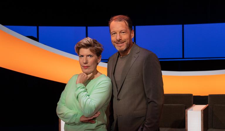 Man en vrouw lachend in een studio